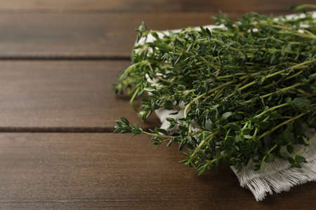 Bunch of aromatic thyme on wooden table, closeup. Space for textの写真素材