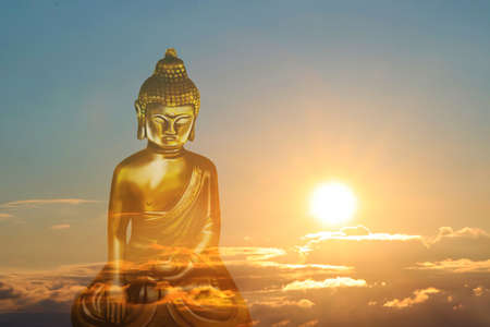 Golden Buddha sculpture and beautfiful sky at sunset on backgroundの写真素材