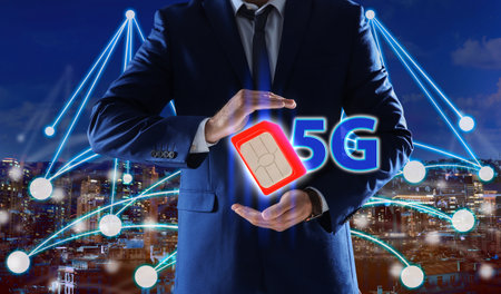 Man demonstrating 5G SIM card model and cityscape with connection lines on background, closeupの写真素材