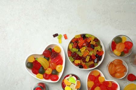 Delicious gummy candies on light gray background, flat lay. Space for text