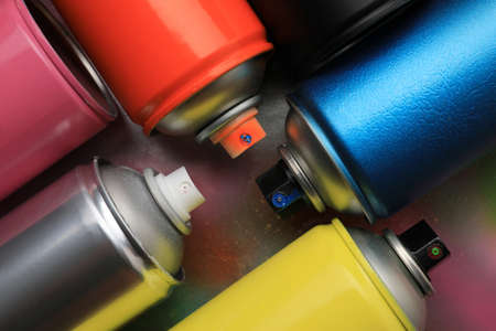 Cans of different graffiti spray paints on color background, flat layの写真素材