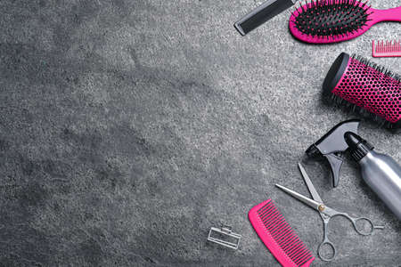 Flat lay composition of professional scissors and other hairdresser's equipment on gray table, space for text. Haircut toolの写真素材