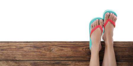Woman wearing stylish flip flops on wooden deck against white background, top viewの写真素材