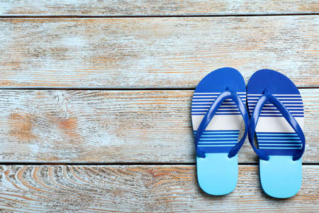 Stylish flip flops on light wooden background, flat lay. Space for textの写真素材