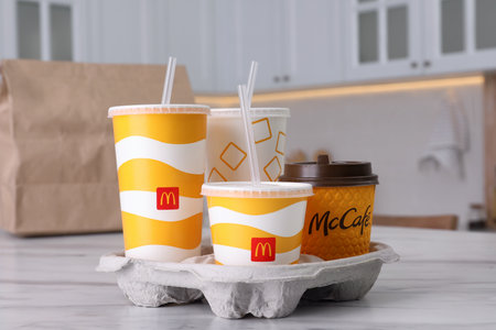 MYKOLAIV, UKRAINE - AUGUST 12, 2021: Cold and hot McDonald's drinks on marble in kitchen