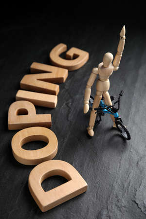 Word Doping, sportsman and bicycle model on black backgroundの写真素材