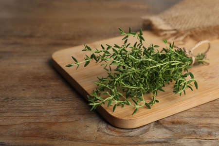Bunch of aromatic thyme on wooden table, closeup. Space for textの写真素材