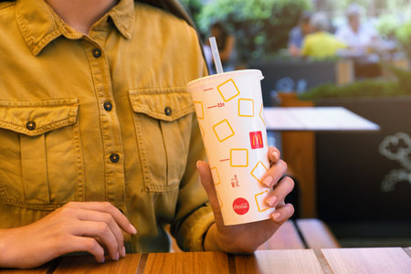 MYKOLAIV, UKRAINE - AUGUST 11, 2021: Woman with cold McDonald's drink in outdoor cafe, closeupのeditorial素材