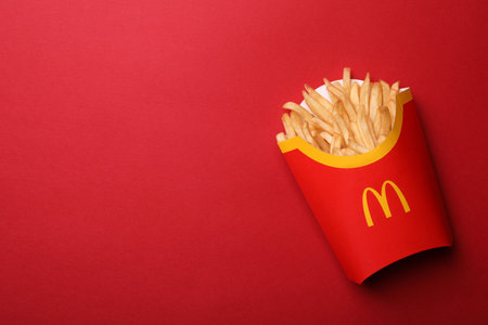 MYKOLAIV, UKRAINE - AUGUST 12, 2021: Big portion of McDonald's French fries on red background, top view. Space for textのeditorial素材