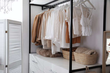 Rack with stylish women's clothes in dressing roomの写真素材