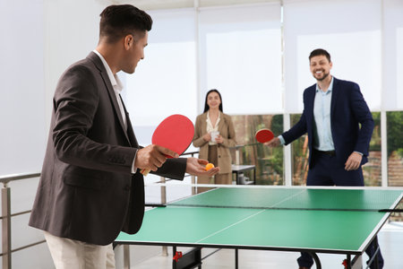 Business people playing table tennis in officeの写真素材