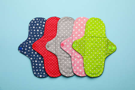 Many reusable cloth menstrual pads on light blue background, flat layの写真素材