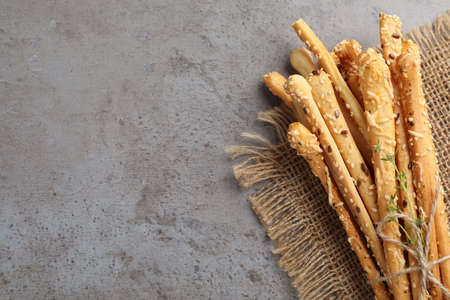 Delicious grissini sticks with thyme on gray table, top view. Space for textの写真素材