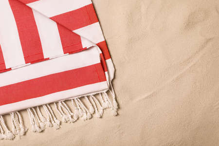 Striped beach towel on sand, top view. Space for textの写真素材