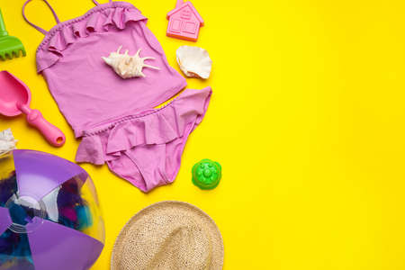 Flat lay composition with beach ball and sand toys on yellow background, space for textの写真素材