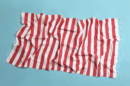 Crumpled striped beach towel on light blue background, top viewの写真素材