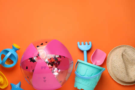 Flat lay composition with beach ball and sand toys on orange background, space for textの写真素材
