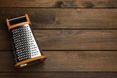 Modern grater on wooden table, top view. Space for textの写真素材
