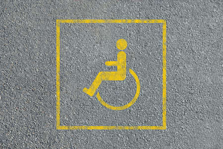 Wheelchair symbol on asphalt road, top view. Disabled parking permitの写真素材