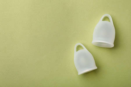 Menstrual cups on light green background, flat lay. Space for textの写真素材