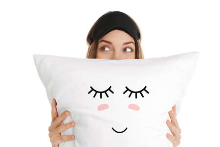 Woman holding pillow with cute face on white backgroundの写真素材