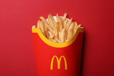 MYKOLAIV, UKRAINE - AUGUST 12, 2021: Big portion of McDonald's French fries on red background, top viewのeditorial素材