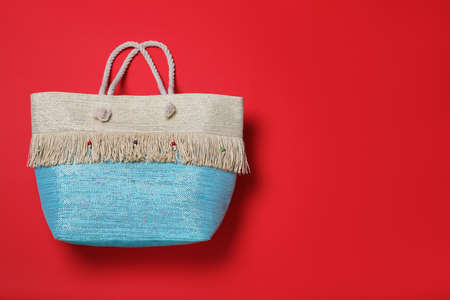 Stylish beach bag on red background, top view. Space for textの写真素材