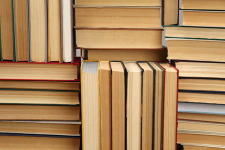 Many hardcover books as background. Library material
