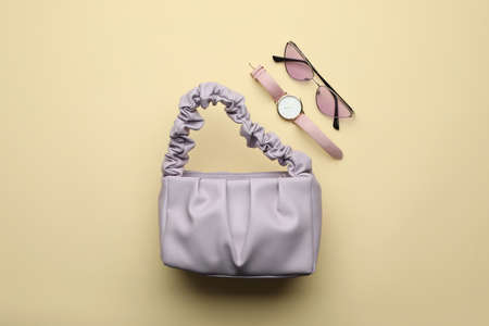 Stylish woman's bag, watch and sunglasses on beige background, flat layの写真素材