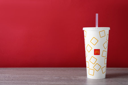 MYKOLAIV, UKRAINE - AUGUST 12, 2021: Cold McDonald's drink on wooden table. Space for textのeditorial素材