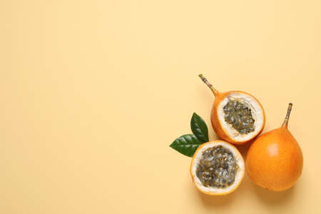 Delicious ripe granadillas with leaves on beige background, flat lay. Space for textの写真素材