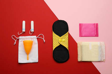 Cloth menstrual pad near other reusable and disposable female hygiene products on color background, flat layの写真素材