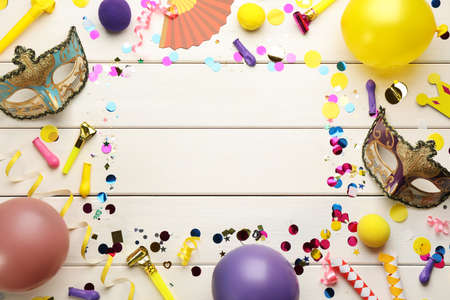 Frame of carnival items on white wooden background, flat lay. Space for textの写真素材