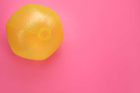 Bright beach ball on pink background, top view. Space for textの写真素材
