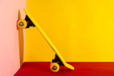 Yellow skateboard on color background. Space for textの写真素材