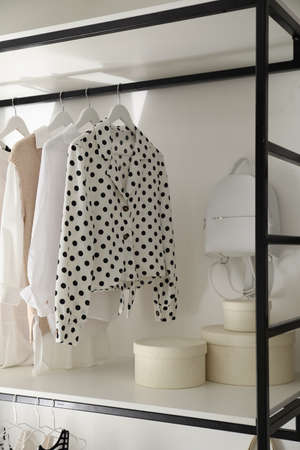 Storage rack with stylish women's clothes and accessories indoorsの写真素材