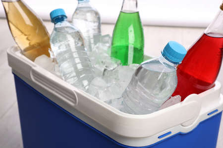 Blue plastic cool box with ice cubes and refreshing drinks, closeupの写真素材