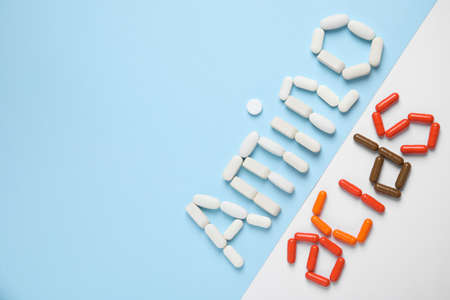 Words "AMINO ACIDS" made with pills on color background, flat lay. Space for textの写真素材
