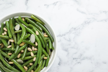 Bowl of tasty salad with green beans on white marble table, top view. Space for textの写真素材