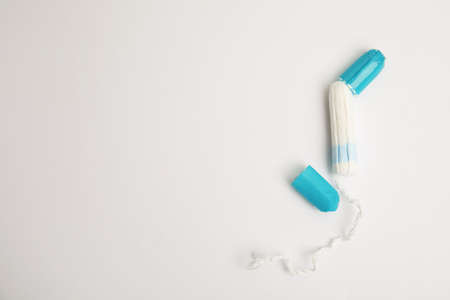 Tampon with package on light background, flat lay. Space for textの写真素材