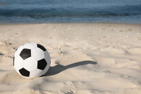 Soccer ball on beach, space for text. Football equipmentの写真素材