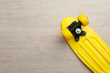 Yellow skateboard on wooden background, top view. Space for textの写真素材