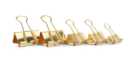 Golden binder clips on white background. Stationery itemの写真素材