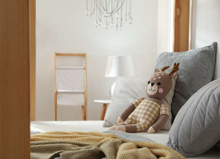Comfortable wooden house bed with cushions and toy in child room. Interior designの写真素材