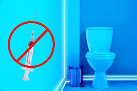 Toilet bowl in public restroom lit with UV blue lightの写真素材