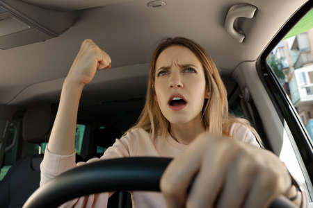 Stressed angry woman in driver's seat of modern carの写真素材