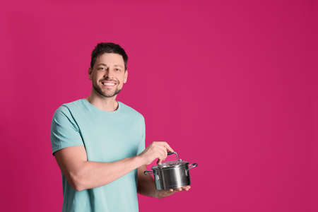 Happy man with pot on pink background. Space for textの写真素材