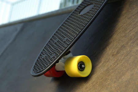 Modern black skateboard on ramp outdoors, closeupの写真素材