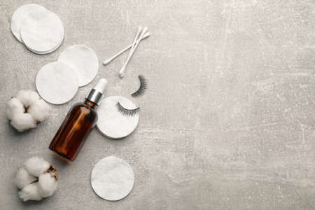Cotton pads, swabs and makeup removal product on gray table, flat lay. Space for textの写真素材