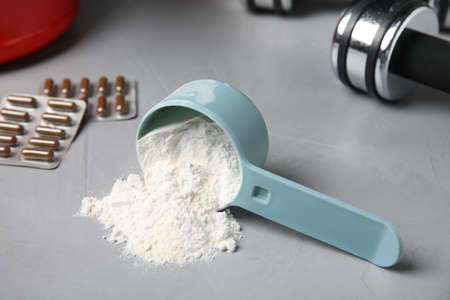 Measuring scoop of amino acids powder on light gray tableの写真素材